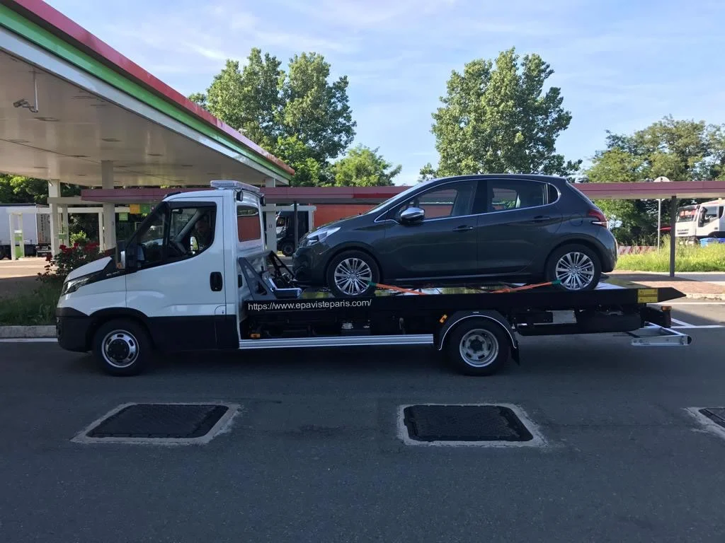 Épaviste chargeant une voiture hors d’usage sur une dépanneuse à Paris